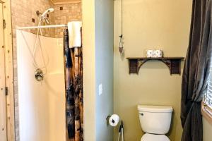 a bathroom with a toilet and a shower with a shower curtain at Poppy's Place Studio in South Fork