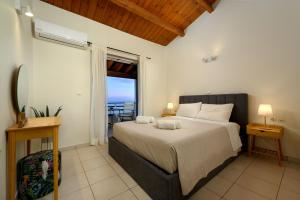 a bedroom with a bed with a view of the ocean at Corfu Glyfada Beach Apartment in Glyfada
