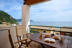a table with two plates of food on a balcony at Corfu Glyfada Beach Apartment in Glyfada