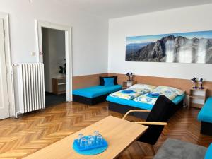 a living room with two beds and a table at Penzion Villa Gerlach in Starý Smokovec