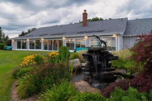 a house with a fountain in front of a yard at OCEAN BAY VIEW Luxury Guesthouse in Musquodoboit Harbour