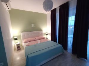 een slaapkamer met een bed en een groot raam bij Ana Rooms in Krk
