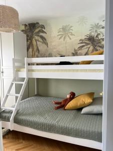 a bunk bed with a stuffed monkey sitting on the bottom bunk at Seaside Apartment Split in Šine