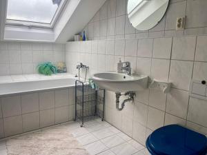 un bagno con un lavandino, una vasca e uno specchio di Wunderschönes großes 3 Zimmer Apartament Zentrum Goldstadt Familienfreundlich mit Garage a Pforzheim Altre 149 foto