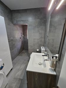 een badkamer met een wastafel en een spiegel bij Brian's Apartment in Tirana in Tirana