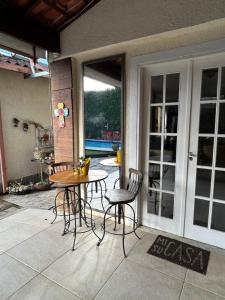d'une terrasse avec une table et des chaises. dans l'établissement Cantinho na Serra, à Teresópolis
