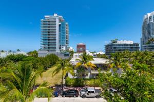 a city with cars parked in a parking lot with palm trees at Shaomi South Beach in Miami Beach