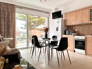 a kitchen with a table and chairs in a kitchen at Beachfront Agia Marina Seafront Resort - Penthouse & Garden, Sleeps 9 in Stalos