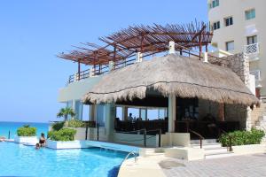 un complexe avec une piscine et un bâtiment dans l'établissement BSEA Cancun Plaza Hotel, à Cancún