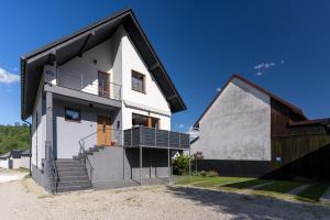 a white house with a black roof at Pokoje Goscinne AnMar in Krościenko