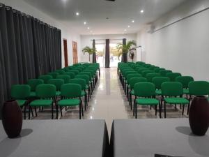 una stanza vuota con sedie verdi in una stanza di Hotel Viajante a Tarrafal