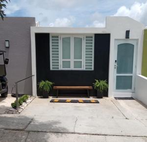 a bench in front of a house with a window at The Yellow Spot in Fajardo