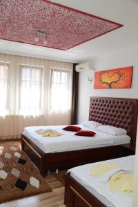 a bedroom with two beds in a room at Hotel Venisi in Prizren