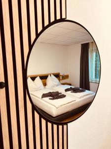 een slaapkamer met een bed met een spiegel aan de muur bij Gasthaus & Hotel Backhendlstation in Enns