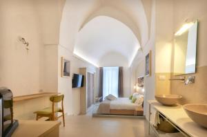 a bathroom with two sinks and a bed in a room at Il Nido Apartment in Montesano Salentino