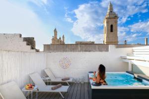 a woman sitting in a swimming pool on top of a building at Il Nido Luxury Apartment in Montesano Salentino