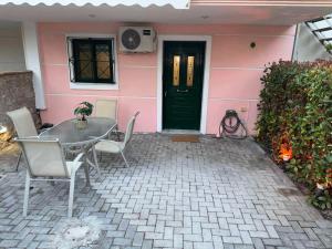a pink house with a table and chairs in front of it at Ifigeleni studios in Ária