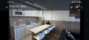 uma cozinha com armários brancos e um balcão de madeira em Stylish Apartment em Playa del Inglés