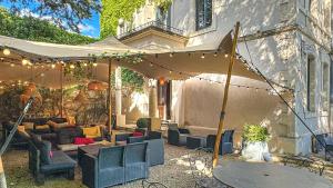 un patio al aire libre con una tienda y sofás en Demeure Saint Louis, Cité 10mn à pieds, PARKING Privé, BORNES 7,2 KW, AC, FULL WIFI, en Carcassonne