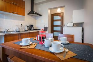 a table with cups and saucers on it in a kitchen at Pokoje Goscinne AnMar in Krościenko