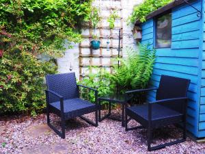 two chairs sitting in front of a blue house at Private Parking & Pillow Paradice With RR Housing in Leamington Spa