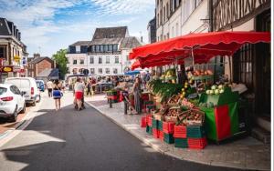 a street with a fruit stand on a city street at Duplex cosy La petite Arche centre Pont de l'arche in Pont-de-lʼArche