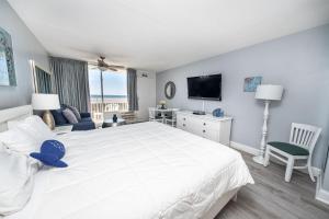 a bedroom with a large white bed and a television at Nassau Inn Beachfront in Wildwood Crest