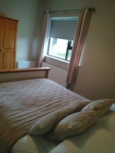 Schlafzimmer mit einem großen Bett und einem Fenster in der Unterkunft Parkhill House Self Catering in Ballyshannon