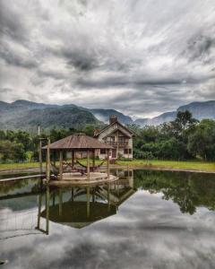 a house with a dock in the middle of a lake at Pousada & Camping Nativos dos Canyons in Praia Grande