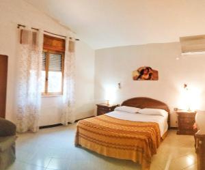 um quarto com uma cama com um cobertor laranja em Villa Posidonie em Marausa