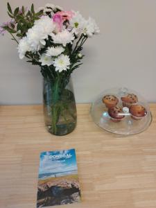 a vase of flowers and some donuts on a table at Parkhill House Self Catering in Ballyshannon
