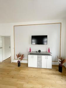 a living room with a flat screen tv on a wall at Wohlfühloase in der City in Luckenwalde +9 photos