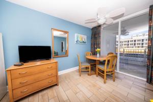 a living room with a television and a dining room table at Nassau Inn Beachfront in Wildwood Crest