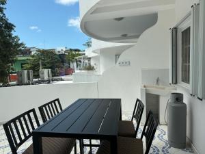 a black table and chairs on a balcony at Amplio departamento en 5ta av in Playa del Carmen