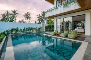 an infinity pool in a villa with a house at The Kaba Kaba Private Luxury Villa in Tumbak Bayuh