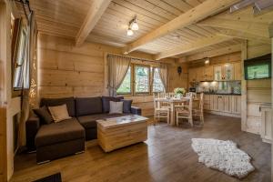 a living room with a couch and a table at DOMKI Szarotka, Rozeta i Parzenica in Ratułów