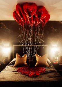 a group of red balloons hanging over a bed at Casa Amor - Kinky Hotel UK in Southampton