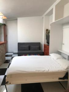1 dormitorio con 1 cama y 1 sofá negro en Apartmani Zaara en Sarajevo