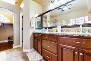 a bathroom with a large vanity and a large mirror at Cardinal Comfort in Litchfield Park +24 photos