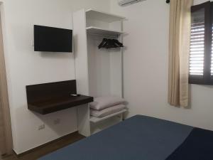 a room with a bed and a tv on a wall at Villa Azzurra in Lampedusa