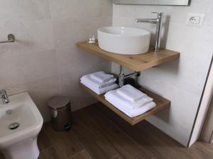 a bathroom with a sink and towels on a shelf at Villa Azzurra in Lampedusa