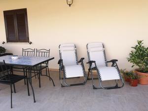 a patio with a table and four chairs and a table at Villa Azzurra in Lampedusa