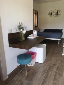 a desk with a vase of flowers and a chair at Villa Azzurra in Lampedusa