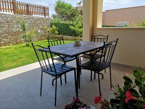 a table and four chairs on a patio at Villa Azzurra in Lampedusa