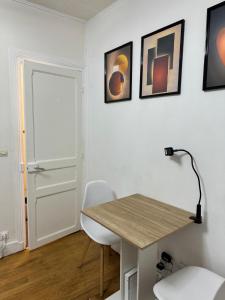 a room with a desk and a table and chairs at chambre d'hote in Issy-les-Moulineaux