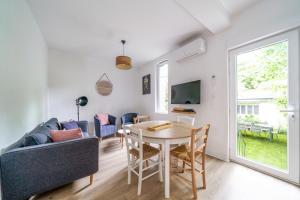 a living room with a table and a couch at Petit coin de nature au coeur de Tours in Tours