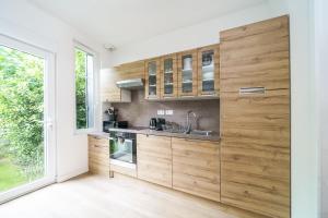 a kitchen with wooden cabinets and a window at Petit coin de nature au coeur de Tours in Tours