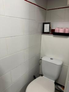 a bathroom with a white toilet and a box of pink towels at chambre d'hote in Issy-les-Moulineaux