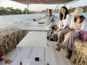 un grupo de personas sentadas en la parte trasera de un barco en ABU Guest House en Asuán