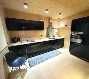a kitchen with a sink and a chair in it at Modernes Ferienchalet in Sörenberg